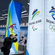 Un journaliste prend des photos d'une exposition au centre d'exposition des Jeux olympiques.