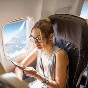 Une jeune femme assise près du hublot dans un avion.