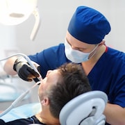 Un dentiste traite un patient.