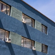 Un immeuble avec des climatiseurs installés à certaines fenêtres.