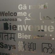 Une vitrine avec le mot Bienvenue traduit en plusieurs langues.