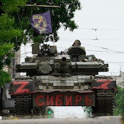 Des membres du groupe Wagner assis au sommet d'un char d’assaut dans une rue de la ville de Rostov-sur-le-Don, le 24 juin 2023.