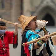 Une femme nisga'a souffle dans un coquillage lors d'une cérémonie tenue devant le parlement du Canada, à Ottawa.
