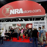 Des membres de la NRA sont devant une boutique de la NRA. 