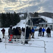 Des skieurs attendent leur tour pour accéder aux pistes de neige.