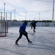 Des joueurs de hockey sur une patinoire à Sept-Iles.