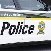 Une voiture de police affichant le logo de la Sûreté du Québec et le mot « Police ».
