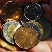 Un homme tient dans sa main des pièces de monnaie