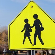 Un panneau jaune indique la présence d'une traverse pour écoliers.