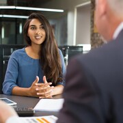Une femme et un homme assis à un bureau lors d'une entrevue d'emploi.