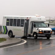 Un véhicule de la Régie intermunicipale de transport Gaspésie–Îles-de-la-Madeleine (RÉGÎM) tourne à un coin de rue.