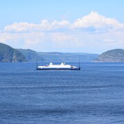 Le projet Énergie Saguenay augmentera le trafic maritime commercial dans le parc marin du Saguenay-Saint-Laurent. On aperçoit le traversier dans le fjord.