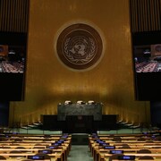 Chambre de l'Assemblée générale des Nations Unies, vue de face du podium avec l'emblème de l'ONU.