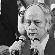 René Lévesque devant deux micros, le 15 novembre 1976. Camille Laurin se trouve en arrière-plan.