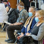 La vaccination contre la COVID-19 est en cours sur la Côte-Nord. Des personnes aînées en attente avec un masque.                         