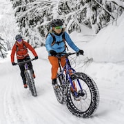 Deux cyclistes pratiquent le vélo à pneus surdimensionnés l'hiver.
