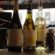 Trois bouteilles de vin et une canette de bière.