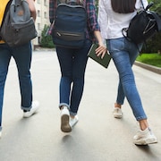 Des étudiants adolescents sur le campus d'une école marchant pendant la pause.