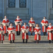 Les juges actuels de la Cour suprême du Canada devant un bâtiment de briques.