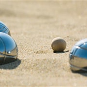 Des boules de pétanque dans le sable.