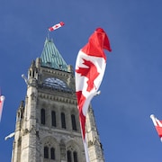 La Tour de la Paix du Parlement du Canada. Des drapeaux du Canada flottent au vent.