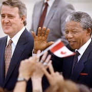 Nelson Mandela salue la foule lors de son arrivée à Ottawa le 17 juin 1990. Il est en compagnie du premier ministre Brian Mulroney.