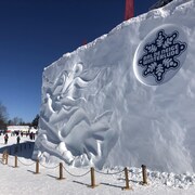La  sculpture de neige arbore le logo de l'événement.