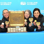 Les nouvelles championnes québécoises de curling féminin posent à côté de leur trophée.