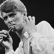 Archive de 1978 de David Bowie, micro à la main, en performance.