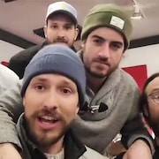Les membres du groupe de musique Le Diable à cinq qui regardent la caméra.
