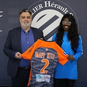 Easther Mayi Kith tient son nouveau maillot en main. 