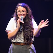 Evelyne Roy-Molgat sur scène avec un micro.