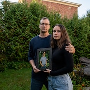 Sébastien Aubé et Emery Jane tiennent une photo dans un cadre. 