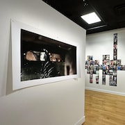 Des photographies sur des murs d'une salle d'exposition.