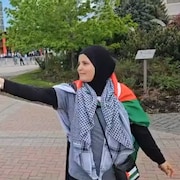 Une femme agite un drapeau.