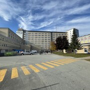 Des employés marchent vers l'Hôpital Fleurimont, à Sherbrooke.