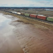Un train sur un chemin de fer le long de l'eau.