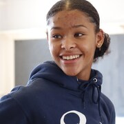Une fille souriante dans une classe de danse.