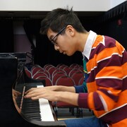 Un garçon qui joue du piano.