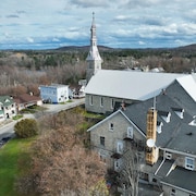 Vue de survol de l'église et du presbytère de Maniwaki où y est installée une antenne de radio.