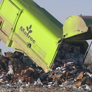 Un camion de transport des déchets vide son contenu dans un site d'enfouissement.