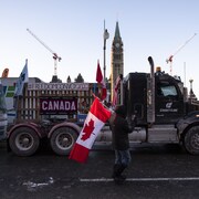 Des camionneurs font partie d'un convoi traversant le pays pour protester contre les mesures sanitaires destinées à freiner la propagation de la COVID-19. Ils sont stationnés sur la rue Wellington, devant la colline du Parlement à Ottawa, le vendredi 28 janvier 2022.