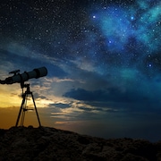 Un télescope pointé vers un ciel étoilé.