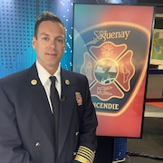 Un homme porte un veston de directeur de pompiers.
