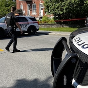 Des policiers travaillent en bordure d'un périmètre de sécurité.