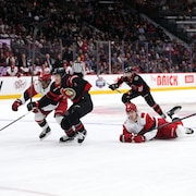 Deux joueurs patinent vers une rondelle libre.