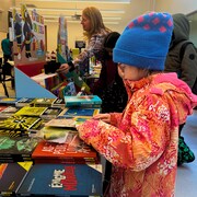 Une enfant lit un livre.