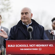 Steven Del Duca devant un pupitre.