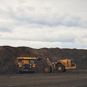 Des camions en activité sur le terrain d'une mine.