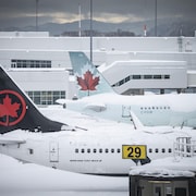 Des avions d'Air Canada enneigés à l'aéroport international de Vancouver.